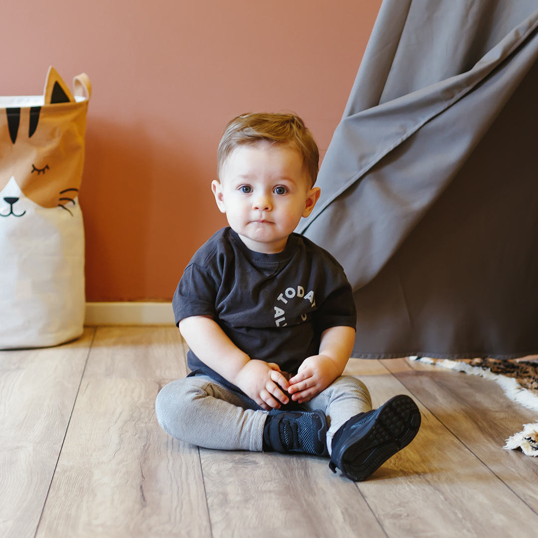 Baby zit op grond bij kinderdagverblijf Kids Lodge