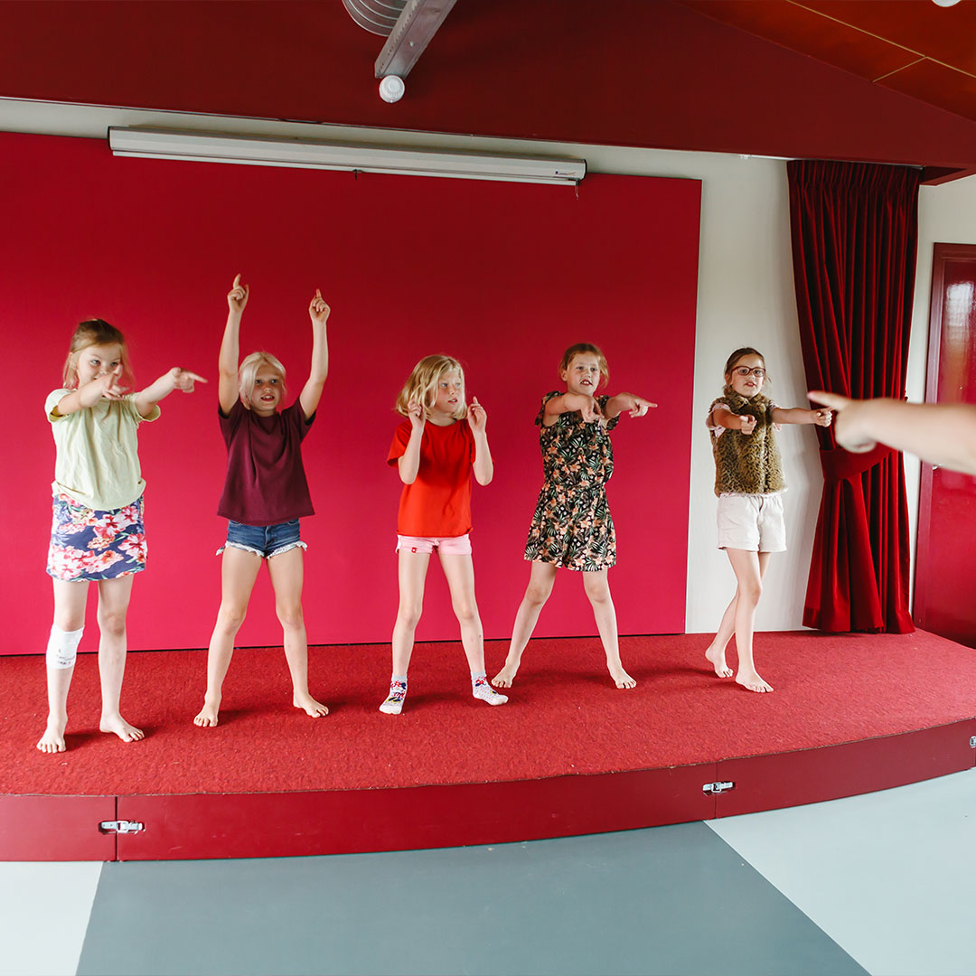 Vijf kinderen staan op een podium en oefenen voor een dansvoorstelling aan de locatie Tuibrug